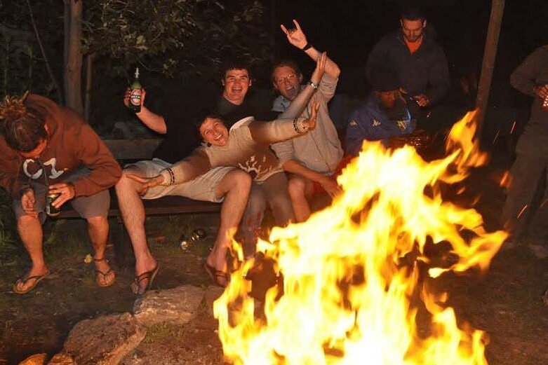 Totem Advenuture A group of friends enjoy an adventure around a campfire at night, where one sips a beer, another plays the accordion and still others cheerfully lift a friend after an exciting day of kayaking in the outdoor paradise of the Aosta Valley. Rafting Kayaking Paragliding Canyoning Aosta Valley