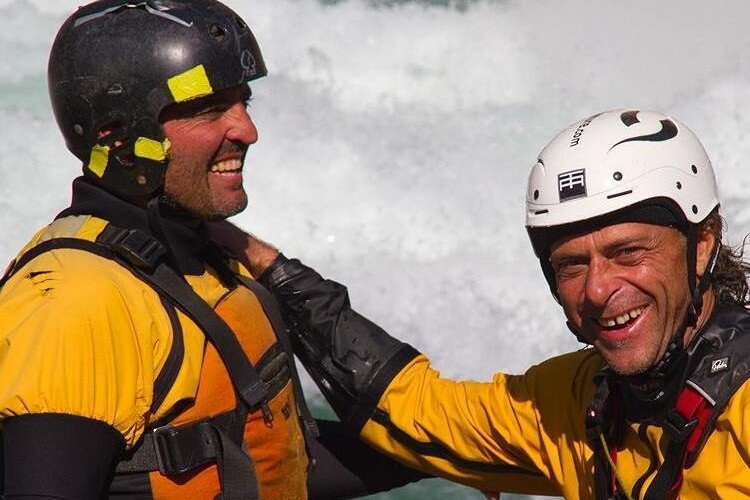 Totem Adventure Two people in yellow outfits and helmets, beaming with excitement, stand proudly before the rushing water. Their bright smiles capture the spirit of adventure as they enjoy an exhilarating rafting experience in the Aosta Valley. Rafting Kayaking Paragliding Canyoning Aosta Valley