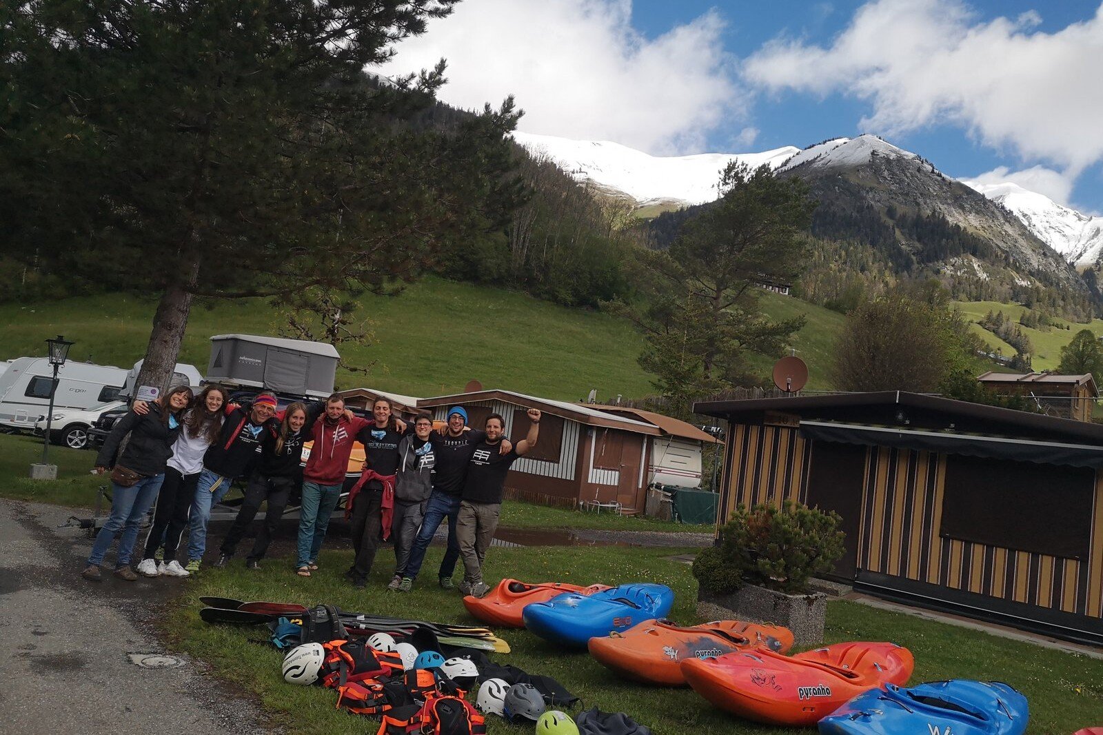 Totem Advenuture A group of adventurers pose with kayaks and equipment at a mountain campsite, ready for exciting outdoor experiences in the Aosta Valley. Rafting Kayaking Paragliding Canyoning Aosta Valley