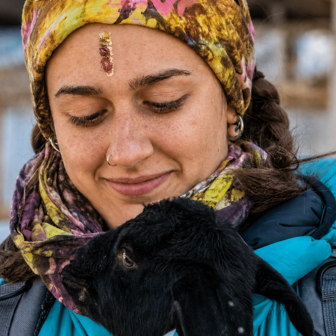 Ritratto di ragazza che tiene in braccio un agnellino nero in Nepal