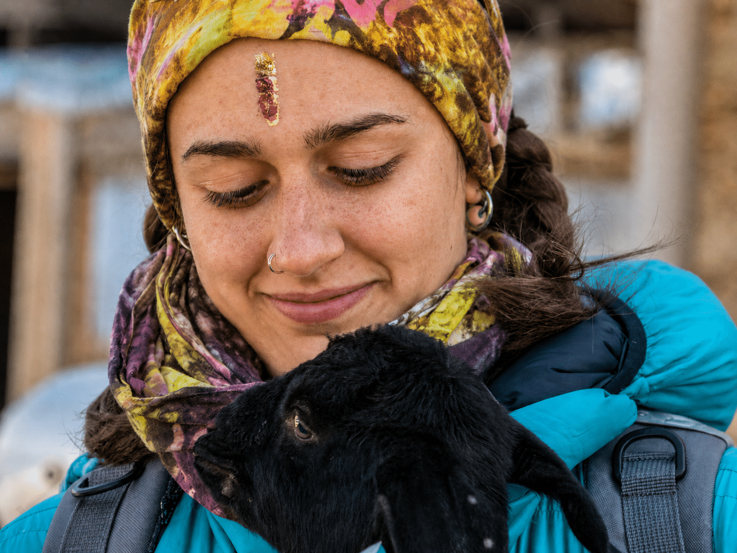 Ritratto di ragazza che tiene in braccio un agnellino nero in Nepal