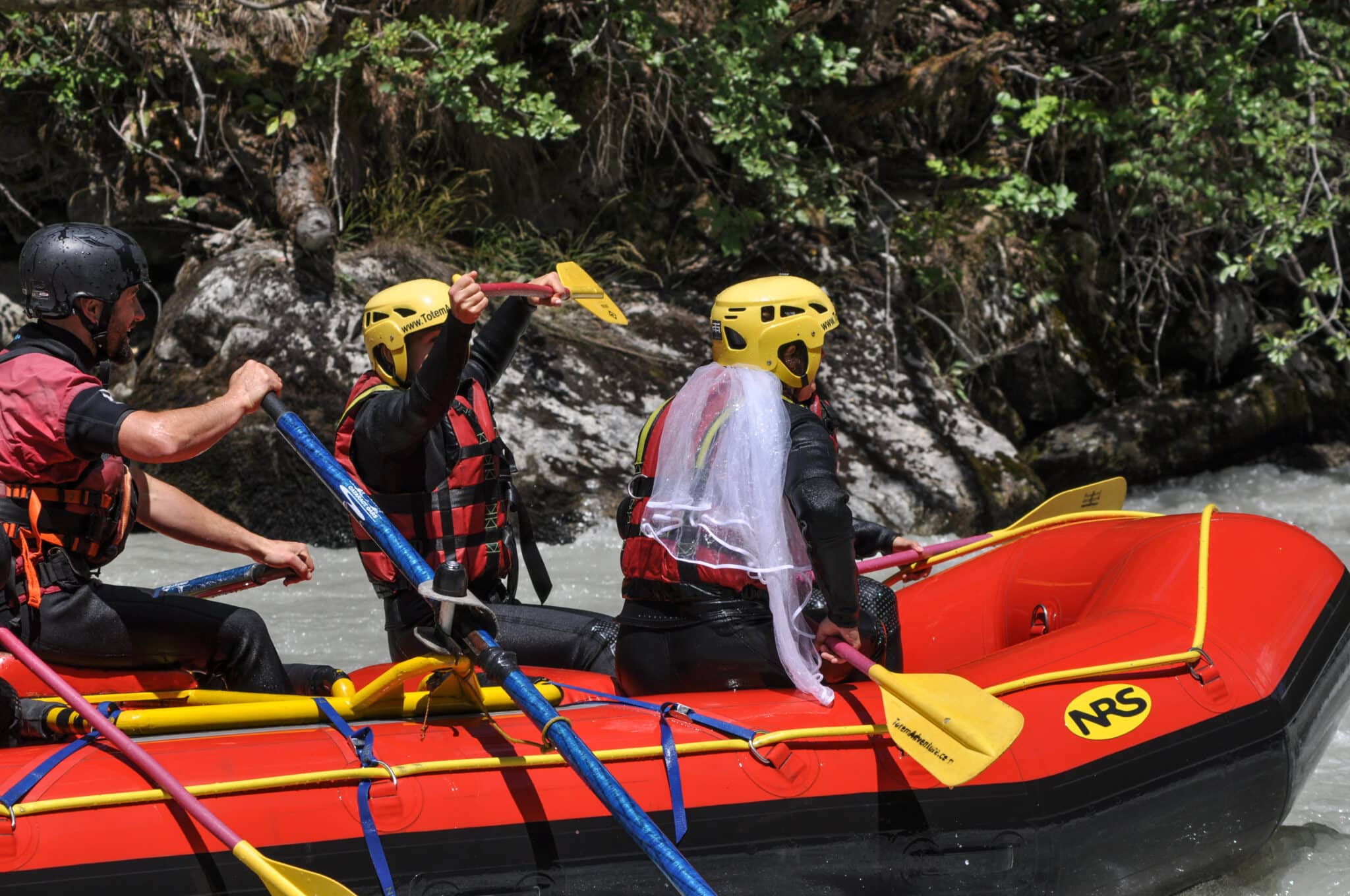 Gruppo di amici durante una discesa di rafting sulla Dora Baltea in Valle d'Aosta per festeggiare addio al celibato